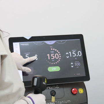 Person in a lab coat using a machine with a digital display